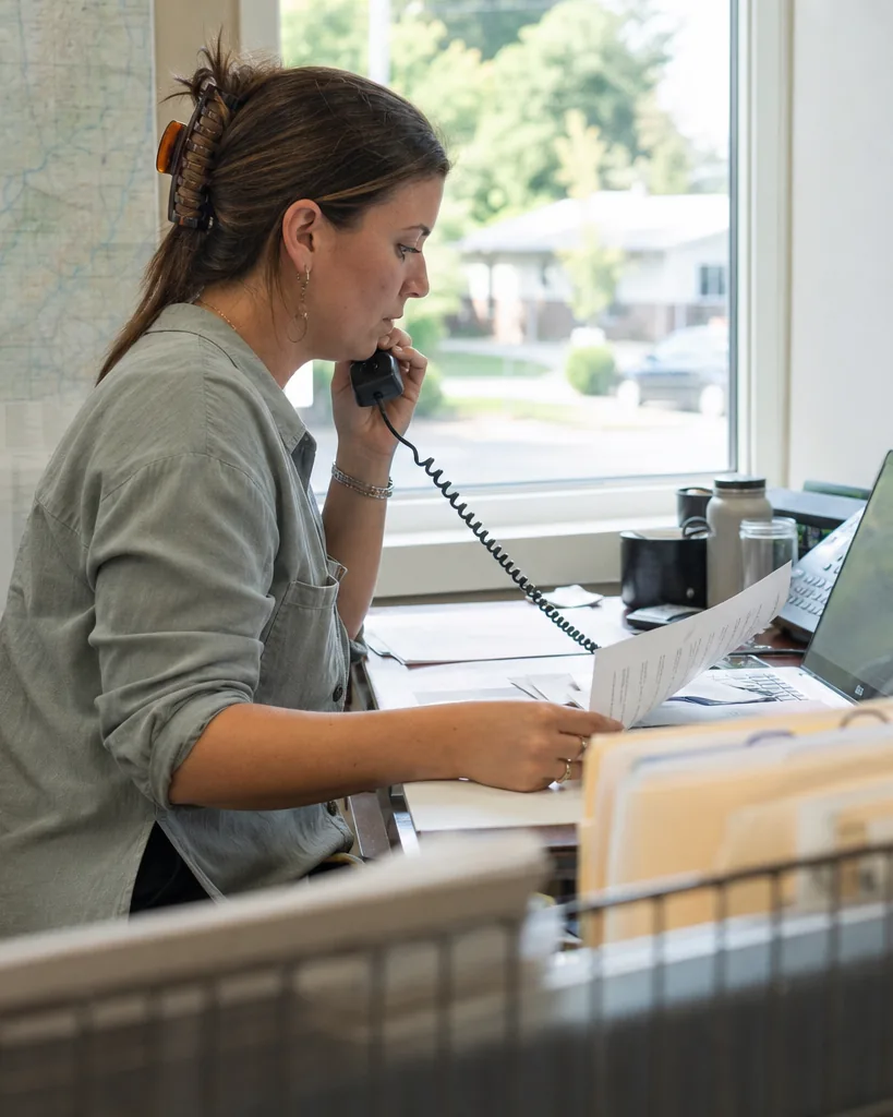 Account manager at an independent insurance agency reviewing a policy change request during a client call